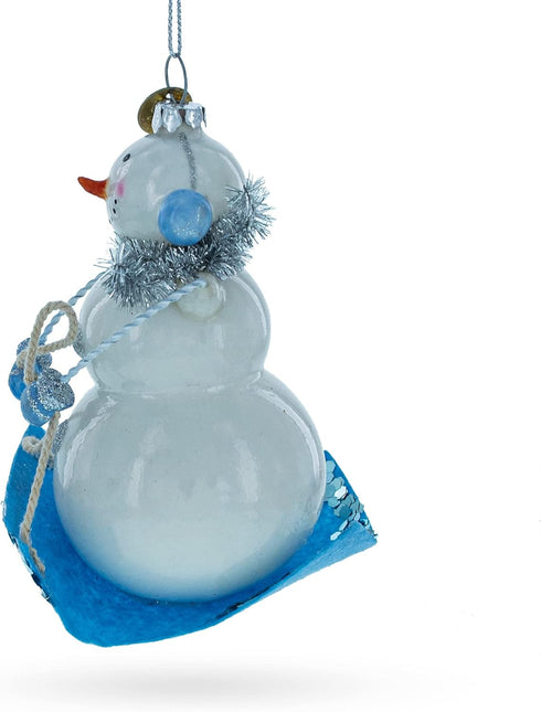 Snowman Riding a Sled - Blown Glass Christmas Ornament