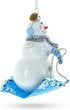 Snowman Riding a Sled - Blown Glass Christmas Ornament